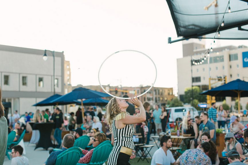 woman balancing a hula hoop on her nose at the night bazaar in Downtown Fargo. 